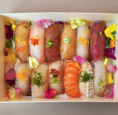 Assorted sushi with decorative flowers in a box